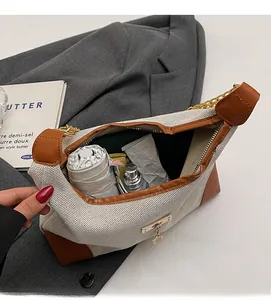 Spacious interior of beige canvas and brown leather crossbody bag showing daily items