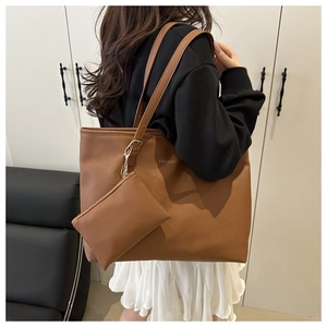 Détail d'un grand sac cabas marron en cuir texturé avec pochette et fermoir métallique