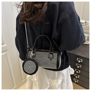 Detail of black rhinestone cylinder bag with metallic chain and matching mini pouch