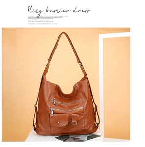 Close-up of vintage brown leather handbag featuring multiple functional zipper pockets