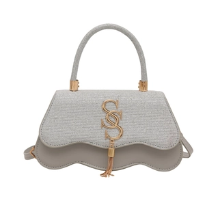 Sac bandoulière argenté avec logo SS doré et pompon élégant de forme carrée moderne