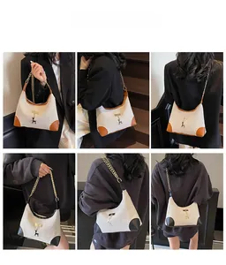 Detail of canvas tote bag featuring leather corners and gold deer pendant on model