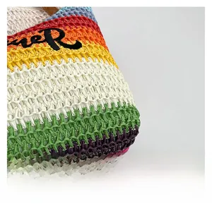 Detailed macro view of multi-color striped woven texture and embroidered letter R on tote