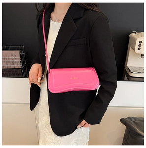 Detail of rose pink leather crossbody bag featuring wave stitching and logo print