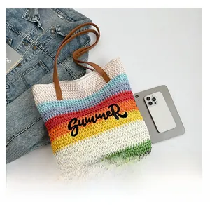 Detailed view of woven straw tote bag with SUMMER embroidery and colorful stripes