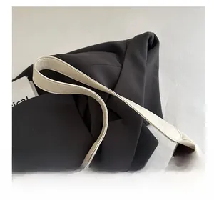 Close-up of white leather tote with wide shoulder strap and contrast brown lining