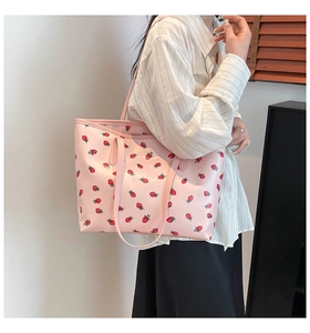 Detail of pink strawberry print tote bag showing fine stitching and durable handles