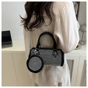 Detail of black cylindrical crossbody bag with silver studs and mini coin purse accessory