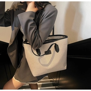 Detail of minimalist canvas tote bag with black faux leather trim and blank rectangular patch