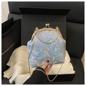 Detail of light blue embroidered butterfly bag with gold handle and chain strap