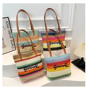 Detail of woven striped tote bag featuring Summer embroidery and leather handles