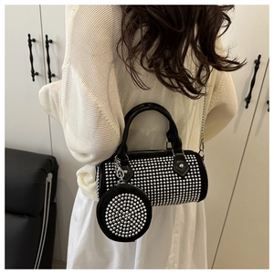 Detail of a black cylindrical bag with silver studs and matching mini round coin purse