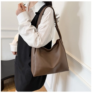 Close-up of a large brown hobo tote bag in premium matte leather with wide shoulder strap