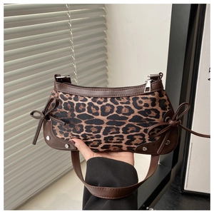 Detail of leopard print underarm bag with leather bow drawstring and silver rivets