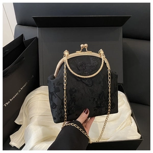 Detail of vintage black butterfly embroidery bag in elegant gift box with gold handle