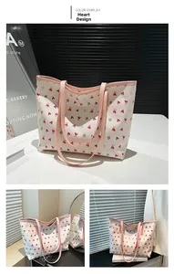 Detail view of cream tote bag featuring cute pink bear prints and leather handles