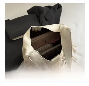 Interior view showing large capacity of the beige fringe tote bag with phone and wallet