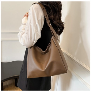 Brown leather large capacity hobo bag showing the drape and size on model shoulder