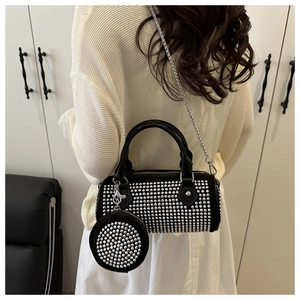 Rear view of a black studded cylinder handbag with a chain strap and a mini pouch