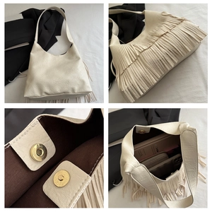 Detail showing the magnetic snap closure and internal storage of the white tassel tote bag