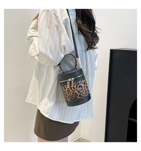 Detail of leopard print bucket bag with metal dual zippers and black leather strap