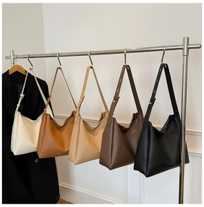 Detailed display of five colorful large leather hobo tote bags hanging on a display rack