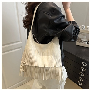 Détail d'un sac hobo blanc crème avec de longues franges et une texture en cuir