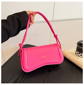 Detail of rose pink handbag with wave-shaped bottom and gold knotted strap decor