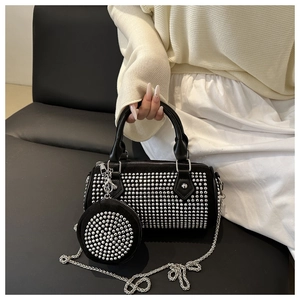 Detail of black cylindrical handbag with silver studs, mini pouch and chain strap