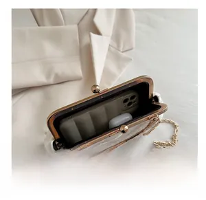 Interior capacity of white lace clutch bag showing space for phone and earphones