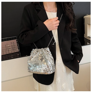 Detail of silver sequin bucket bag with metal chain strap and drawstring closure