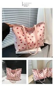 Detail of pink strawberry print tote bag with smooth texture and long handles