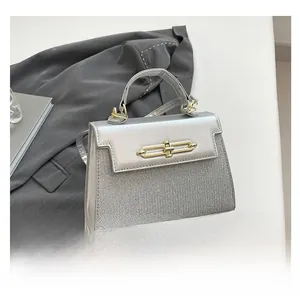 Detail of silver patchwork handbag with metallic mirror finish and golden twist-lock closure