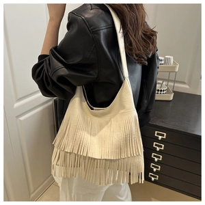 Model wearing a cream fringe shoulder bag in matte leather for a vintage commuter style