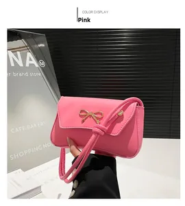 Close-up of pink bag with a gold metal bow buckle on smooth synthetic leather