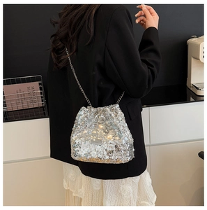 Detail shot of shimmering silver sequin bucket bag with elegant metal chain shoulder strap
