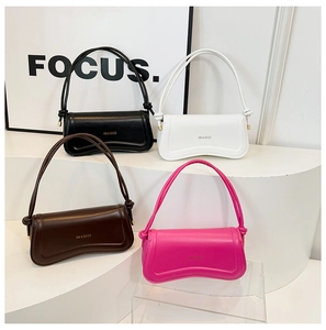 Detail view of four colorful wave-shaped leather handbags on a minimalist white stand
