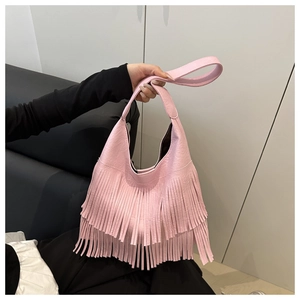 Détail du sac à main rose à franges avec pompons et texture en simili cuir souple