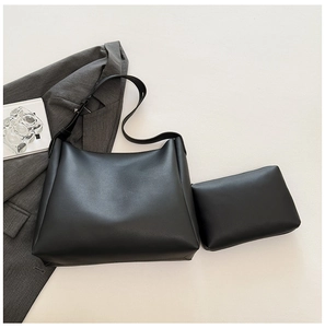 Minimalist black leather tote bag set with inner pouch shown in a modern urban office setting