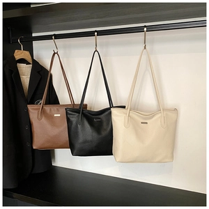 Détail des grands sacs cabas en similicuir marron, noir et beige avec texture grainée