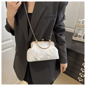 Detail of white lace kiss lock bag with 3D butterfly embroidery and gold metal handles
