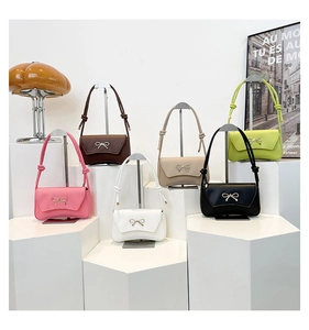 Detail of elegant shoulder bags with metal bow in six colors on geometric stands