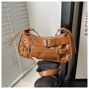 Close-up of caramel leather shoulder bag with silver rivet belts and retro buckles