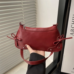 Deep red crescent underarm bag with sweet double bow details and silver hardware
