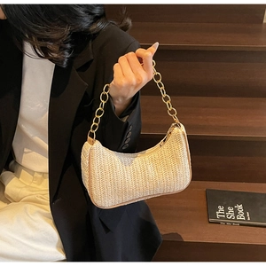 Detail of beige woven hobo bag featuring V-texture craftsmanship and a gold chunky chain