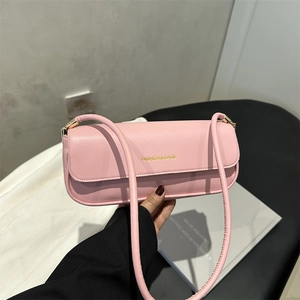 Pink minimalist PU leather underarm bag with gold lettering shown in a 45-degree angle