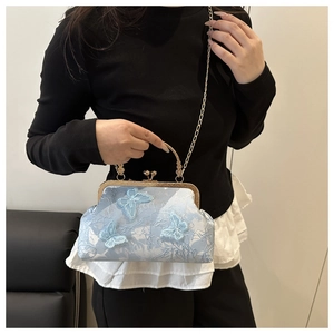 Detail of light blue lace shell bag with 3D butterfly embroidery and gold clasp