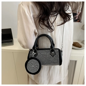 Detail of black cylindrical crossbody bag with silver studs and small round coin purse