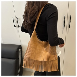 Détail de la frange marron multicouche sur un sac cabas rétro porté par un mannequin