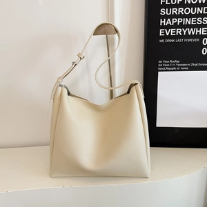 Minimalist cream leather tote bag for women shown on a stylish modern display stand